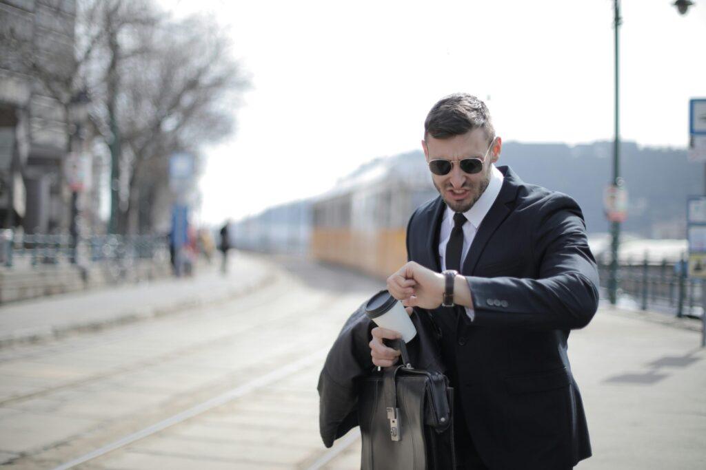 Man in Black Suit Jacket Holding Black Leather Bag scaled