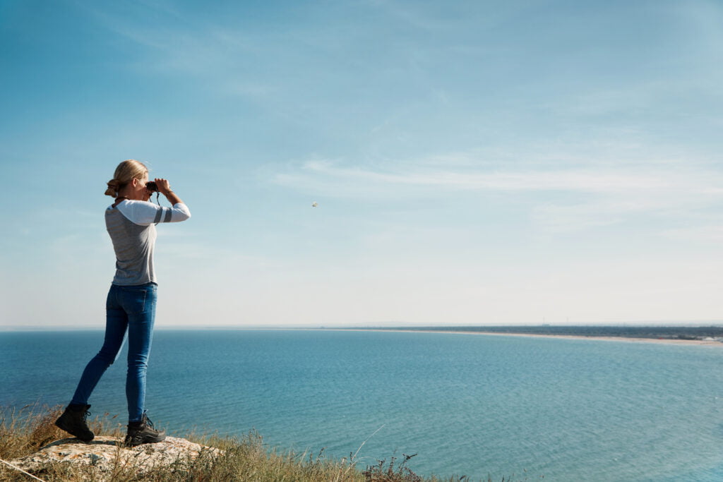 woman looking through binoculars