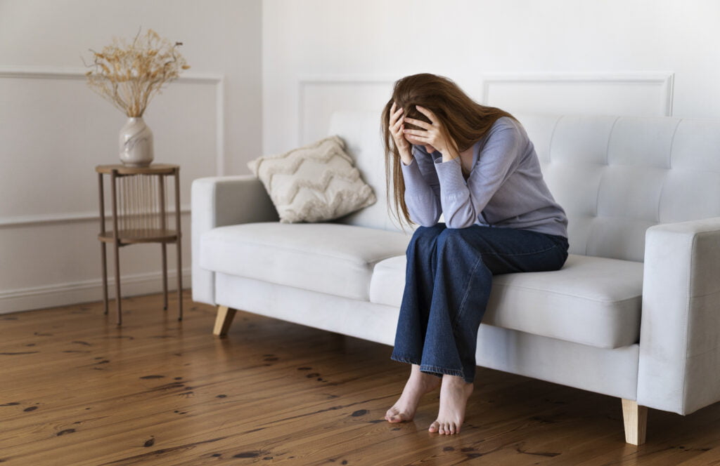 full shot anxious woman sitting couch